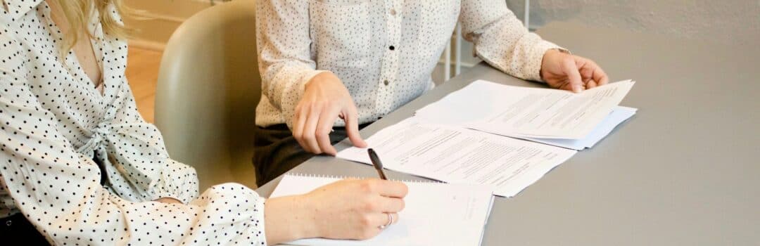 A homebuyer and advisor reviewing mortgage documents together