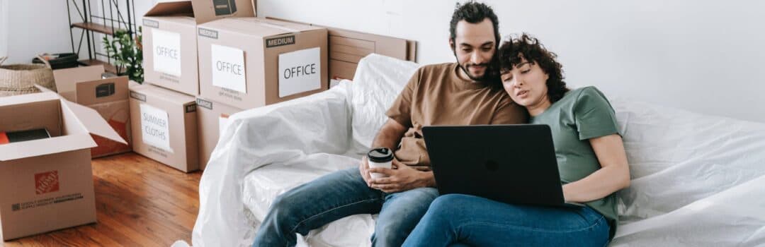 A couple planning their home purchase with moving boxes nearby